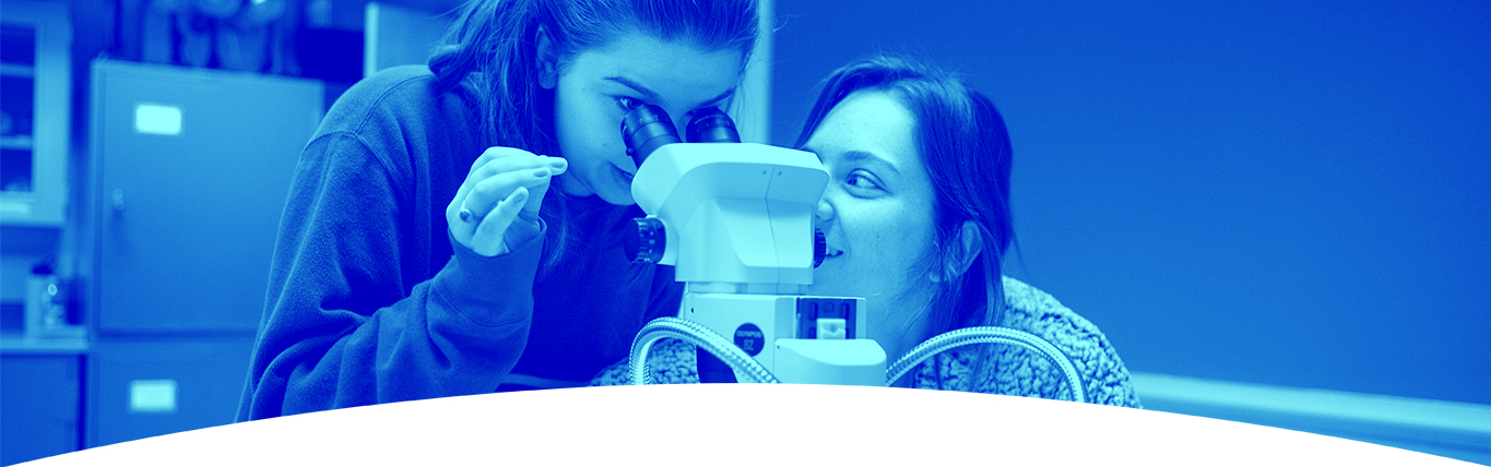 Top image of two females looking through a microscope together.