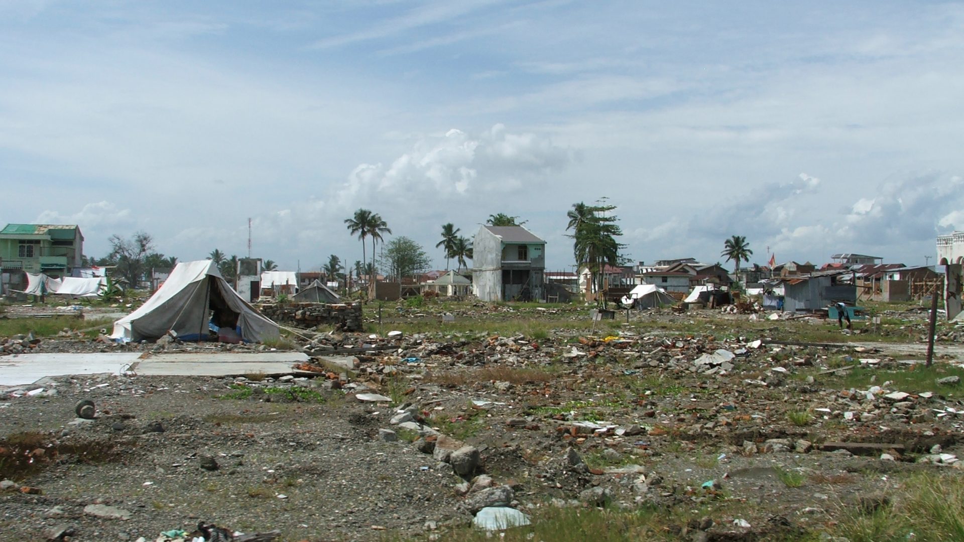 battered homes and debris fill the landscape after the 2004 Indian Ocean tsunami.
