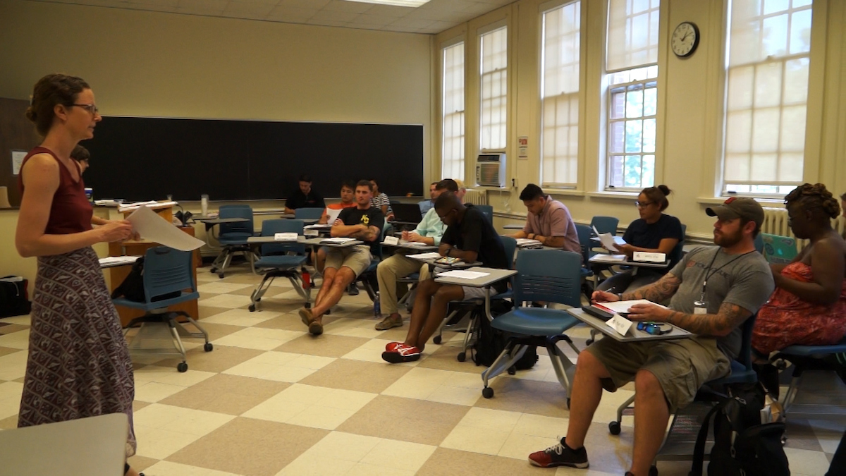 Dr Hilary Lithgow stands in front of one of her English classes, teaching.