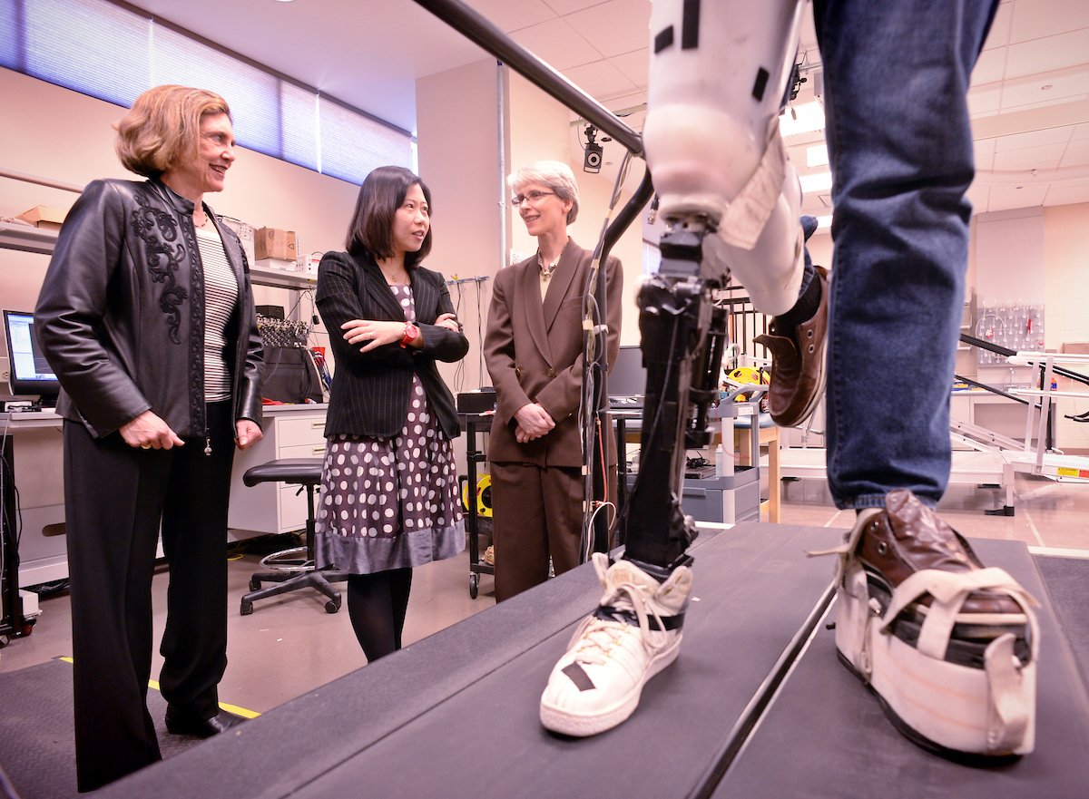 Three female researchers talk while in the Biomed engineering lab at NC State University.