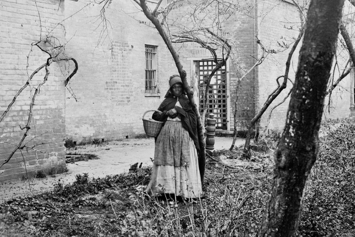 Old black and white photo of an African American women foraging.