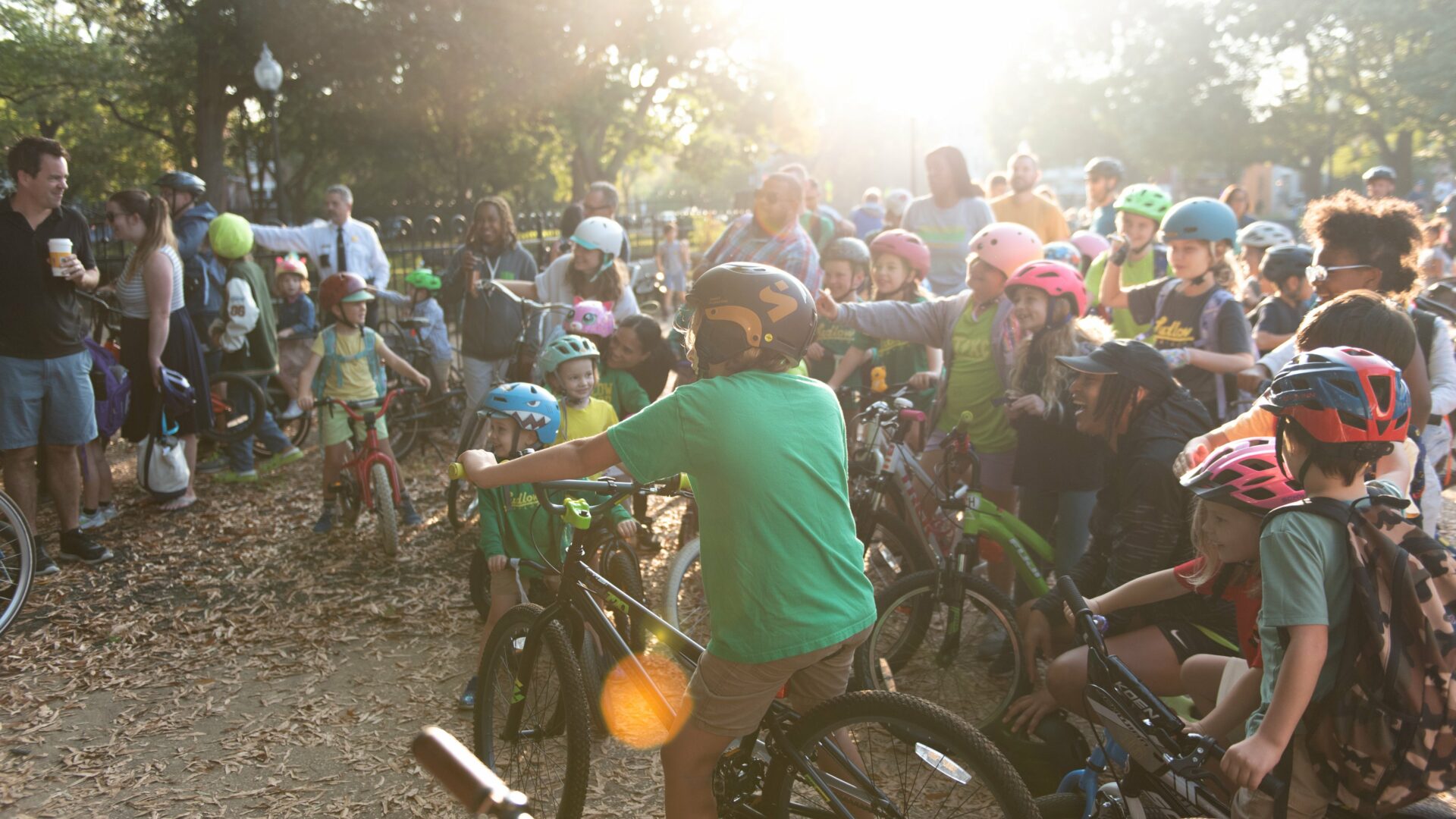 Large group of kids on their bikes, wearing helmets.