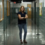 Photo of Dorothy Espelage standing in a high school hallway with her arms crossed.