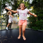 Hope smiles as she jumps on a trampoline.