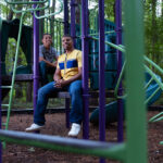 A father and his son pose for a photo at a local park.