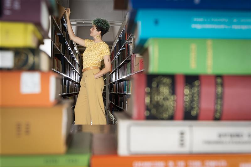 Women searching through books in a library.