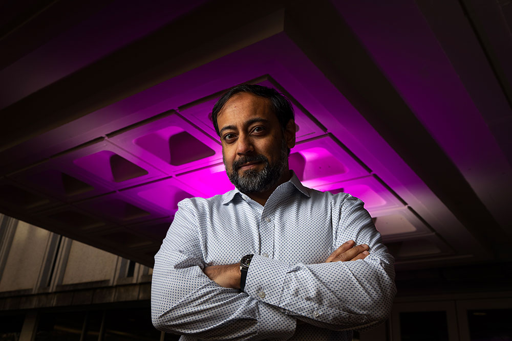 Nab Dasgupta in a room with pink lighting behind him