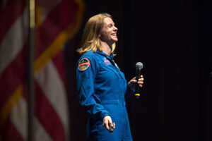 Photo of Zena Cardman in her blue NASA jumpsuit while on stage during her keynote event.